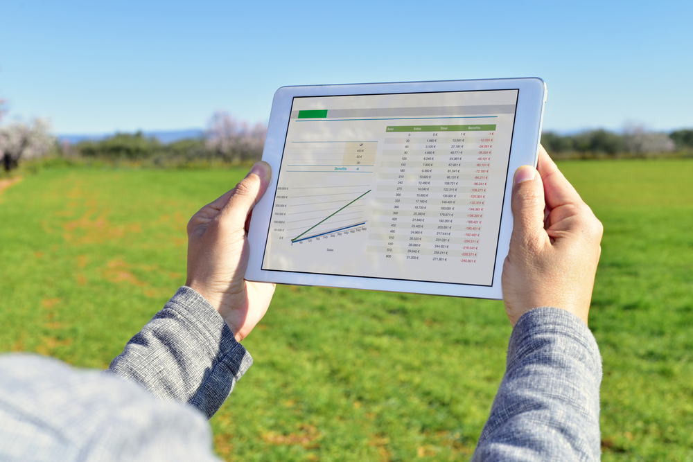 farmer observing charts on tablet computer